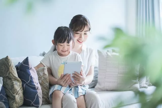 女の子と一緒にタブレットを見る母親