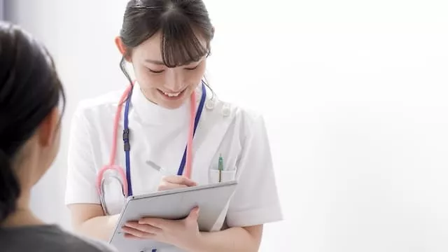 患者と話す医療事務スタッフ