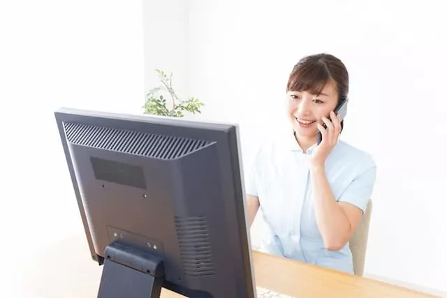 パソコンの前で電話する医療事務スタッフ
