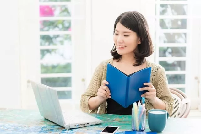 パソコンを見ながら医療秘書検定について調べる女性