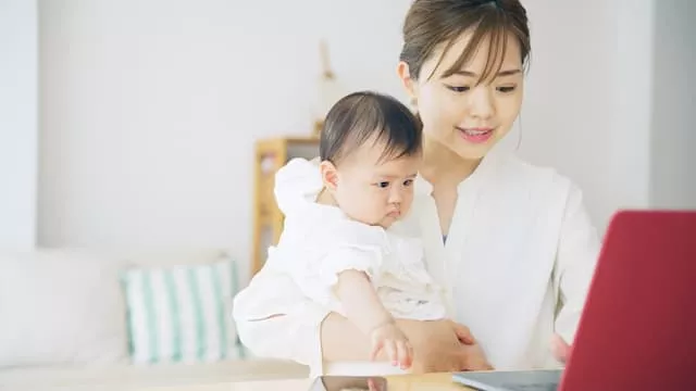 パソコンを見る子育て中の女性